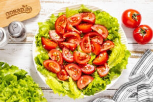 Салат из помидоров с чесноком и зелёными листьями